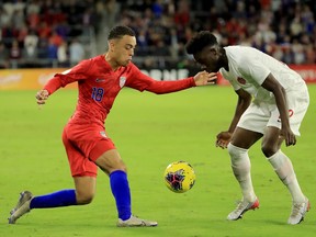 Sergino Dest of the United States, left, attempts to drive past Alphonso Davies of Canada during the CONCACAF Nations League match at Exploria Stadium on November 15, 2019 in Orlando, Florida.