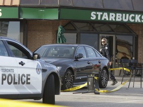 A Toronto Police officer is pictured at the scene of a Nov. 4, 2019  murder at a plaza on The Queensway and North Queen St. (Stan Behal, Toronto Sun)