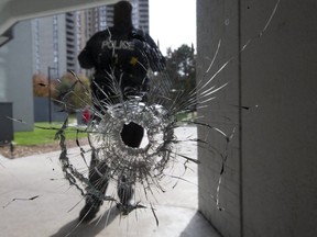 Toronto Police investigated the bullet-riddled scene at the front entrance of a building near Trethewey and Black Creek Drs. on Nov. 4, 2019. (Stan Behal, Toronto Sun)