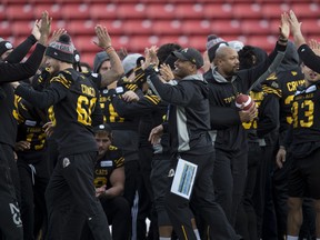 Hamilton Tiger-Cats head coach Orlondo Steinauer gives high fives during a practice prior to the 107th Grey Cup in Calgary, Saturday, Nov. 23, 2019. THE CANADIAN PRESS/Todd Korol