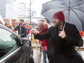 Protesting teachers gather around Ontario Education Minister Stephen Lecce's car as he is driven from a Toronto school after making an announcement on Wednesday, Nov. 27, 2019.  THE CANADIAN PRESS/Chris Young