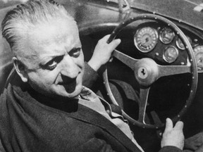 Enzo Ferrari (1898 – 1988), the Italian car designer, behind the wheel of one of his cars.