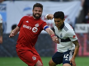 Toronto FC defender Drew Moor, left, challenges Vancouver Whitecaps forward Fredy Montero (12) during the first half at BC Place May 31, 2019 Anne-Marie Sorvin-USA TODAY)