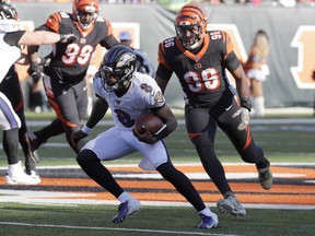 Baltimore Ravens quarterback Lamar Jackson (8) runs against Cincinnati Bengals defensive end Carlos Dunlap (96) during the second half at Paul Brown Stadium. David Kohl-USA TODAY Sports