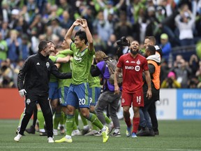 Seattle Sounders midfielder Kim Kee-Hee (20) celebrates after the MLS Cup against Toronto FC midfielder Nick DeLeon (18) at CenturyLink Field. Steven Bisig-USA TODAY Sports