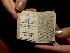 An employee displays the second issue of Young Men's Magazine, a miniature manuscript dated 1830, written by Charlotte Bronte when she was 14 years old, before being put on auction at Drouot auction house in Paris, France, Nov. 18, 2019.