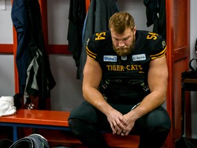 Tiger-Cats’ Chris Van Zeyl sits dejected in the Hamilton locker room after his team’s loss to the Winnipeg Blue Bombers in Sunday’s Grey Cup game.  (Azin Ghaffari/Postmedia Network)