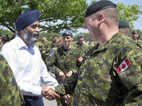 Defence Minister Harjit Sajjan talks with soldiers after announcing investments in infrastructure for the 5th Canadian Division Support Base at CFB Gagetown in Oromocto, N.B. on Monday, June 27, 2016. (THE CANADIAN PRESS/Andrew Vaughan)