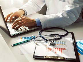 A doctor working at a laptop.