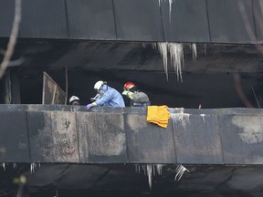 Toronto Fire and the Ontario Fire Marshal’s investigators on the eighth floor balcony where a person died when flames erupted at a highrise on Gosford Blvd. on Friday, Nov. 15, 2019. (Jack Boland/Toronto Sun/Postmedia Network)