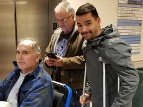 Toronto Fire Captain Warren (seated) and firefighter Terry Leimonis (crutches) leaving St. Mike's Hospital together on Saturday, Nov. 24, 2019. Both men were injured in a fall while battling a blaze at a downtown building on Nov. 2. (@ChiefPeggTFS on Twitter)