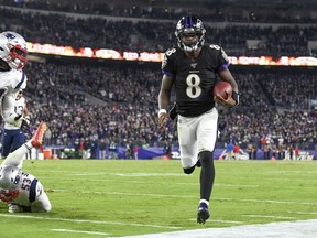 Baltimore Ravens quarterback Lamar Jackson runs with the ball during the third quarter against the New England Patriots at M&T Bank Stadium.