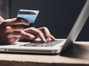 Man shopping online using laptop computer and credit card