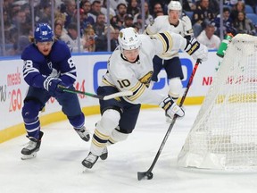Buffalo Sabres defenseman Henri Jokiharju carries the puck around the net while Toronto Maple Leafs center William Nylander tries to defend during the first period at KeyBank Center.
