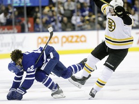 Trevor Moore gets checked at centre ice by Chris Wagner in first period action as the Toronto Maple Leafs take on the Boston Bruins  in Toronto on Friday, Nov. 15, 2019.