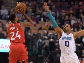 Raptors guard Norman Powell (left) shoots the ball past Hornets forward Miles Bridges (right) during first half NBA action at Scotiabank Arena in Toronto, Monday, Nov. 18, 2019.