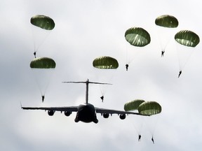 In this 2012 file photo, Canadian military paratroopers exit a C-17 Globemaster aircraft during an exercise in Prince Edward County, south of Trenton, Ont. (Photo by Sgt. Ron Flynn, Royal Canadian Air Force)