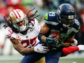 Richard Sherman, left, of the 49ers attempts to tackle Seahawks' Doug Baldwin, right, during NFL action at CenturyLink Field in Seattle, on Dec. 2, 2018.