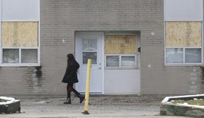A pedestrian passes Unit 209 of a TCHC townhouse on Grandravine Dr. Thursday, November 7, 2019, the day after it was sprayed with 21 bullets. Stan Behal/Toronto Sun