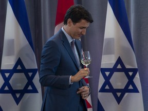 Prime Minister Justin Trudeau walks off the stage after toasting Israeli President Reuven Rivlin during a luncheon in Ottawa, on Monday, April 1, 2019. (THE CANADIAN PRESS/Adrian Wyld)