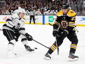 John Moore of the Boston Bruins defends Nikolai Prokhorkin of the Los Angeles Kings during the second period at TD Garden on December 17, 2019 in Boston, Massachusetts.