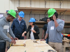 Minister Monte McNaughton, second from left, chats with BOLT executive director Joanne Bin at the 2019 Day of Discovery as students participate in a workshop at George Brown College.