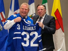 Premier Doug Ford presents a Maple Leafs jersey to his Quebec counterpart, Francois Legault, in Toronto on Dec. 2, 2019.