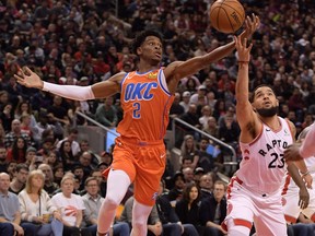 Oklahoma City Thunder guard Shai Gilgeous-Alexander, left, and Toronto Raptors guard Fred VanVleet battle for a loose ball in the first half at Scotiabank Arena, Dec. 29, 2019.