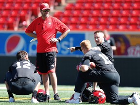 Stamps quarterbacks coach, Ryan Dinwiddie, here huddling with Bo Levi Mitchell (right) and some other QBs on the team, is the new head coach of the Argonauts, replacing Corey Chamblin who lasted just one year.  AL CHAREST/POSTMEDIA