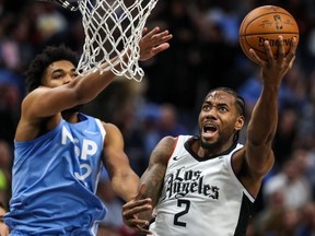Los Angeles Clippers forward Kawhi Leonard shoots over Minnesota Timberwolves center Karl-Anthony Towns  during the second quarter at Target Center.