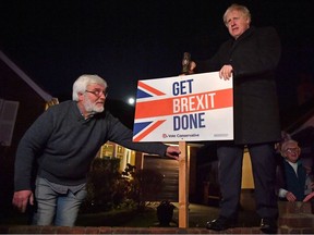 Britain's Prime Minister and Conservative party leader Boris Johnson poses with a sledgehammer, and a "Get Brexit Done" sign, next to his supporter, in South Benfleet, Britain December 11, 2019.
