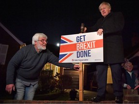 Britain’s Prime Minister and Conservative party leader Boris Johnson poses with a sledgehammer, and a “Get Brexit Done” sign, next to his supporter, in South Benfleet, Britain December 11, 2019.