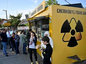 Visitors wait in line to buy snacks and souvenirs at a souvenir shop next to the Dytyatky checkpoint after a tour in the Chernobyl exclusion zone on June 7, 2019.