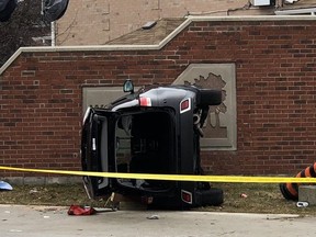 A car lies on its side at the intersection of Guildwood Way and Eglinton Ave. W. in Mississauga after at attempted carjacking. The owner, who attempted to stop the thief, is in critical condition after being dragged.