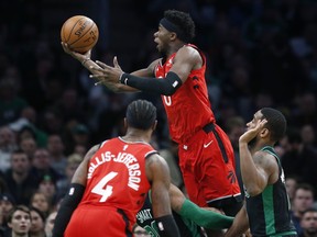Raptors’ Terence Davis fouls Celtics’ Marcus Smart while shooting during the first half of Saturday night’s game in Boston. Toronto coach Nick Nurse wants a more spread-out offence. (THE ASSOCIATED PRESS)