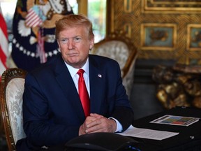 U.S. President Donald Trump answers questions from reporters after making a video call to the troops stationed worldwide at his Mar-a-Lago estate in West Palm Beach, Fla., Tuesday, Dec. 24, 2019.
