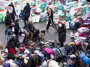 Residents of the Francis Drake Hotel apartment building receive donated gift boxes after the building caught a fire Wednesday, Dec. 25, 2019, in Minneapolis. Hundreds of people donated diapers, clothing and personal items after the early morning fire tore through the apartment building. The building mostly serves as temporary housing for homeless people.