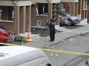 Police collect evidence at the scene of a deadly shooting outside a townhome on Chevron Prince Path in Oshawa on Tuesday.
