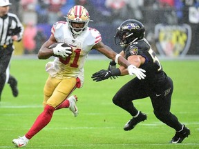 San Francisco 49ers running back Raheem Mostert runs with the ball while being pursued by Baltimore Ravens linebacker L.J. Fort in the second quarter at M&T Bank Stadium.