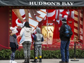 Toronto onlookers stop to admire the holiday window displays at the flagship Hudson's Bay store at Queen and Yonge Sts. on Thursday, Dec. 5, 2019. (Stan Behal/Toronto Sun/Postmedia Network)