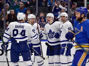 Toronto Maple Leafs left wing Zach Hyman  is congratulated by defenseman Morgan Rielly and defenseman Tyson Barrie and center John Tavares after scoring during the first period against the St. Louis Blues at Enterprise Center.