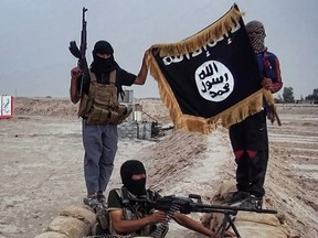 An image made available on the jihadist website Welayat Salahuddin shows militants of the Islamic State of Iraq and the Levant (ISIL) posing with the trademark Jihadists flag after they allegedly seized an Iraqi army checkpoint in the northern Iraqi province of Salahuddin June 11, 2014.