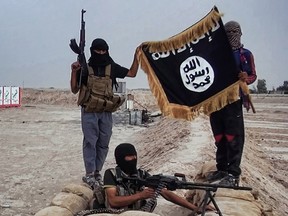In this file photo taken on June 11, 2014, an image made available on the jihadist website Welayat Salahuddin shows militants of the Islamic State of Iraq and the Levant (ISIL) posing with the trademark Jihadists flag after they allegedly seized an Iraqi army checkpoint in the northern Iraqi province of Salahuddin. A Guelph, Ont., man, Ikar Mao, who was arrested in Turkey near its border with Syria, allegedly with propaganda videos from ISIS on his cellphone, was charged on Dec. 6, 2019, with terrorism offences.
