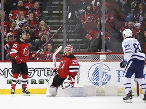 Damon Severson (left) and goaltender Mackenzie Blackwood of the New Jersey Devils react after losing 5-4 in overtime to the Toronto Maple Leafs at the Prudential Center on Friday night. (Bruce Bennett/Getty Images)