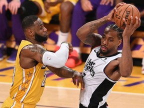 Lakers forward LeBron James (left) guards Clippers forward Kawhi Leonard (right) during a Christmas Day NBA match-up between both Los Angeles-based teams at the Staples Center, Dec. 25, 2019.