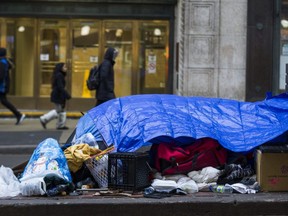 Tarps and an umbrella form a makeshift  shelter on the boulevard along Yonge St., just south of College St., in Toronto, Ont. on Thursday December 26, 2019.