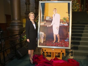 Former Ontario premier Kathleen Wynne stands beside her portrait, painted by Linda Dobbs, after its unveiling ceremony at the Ontario legislature, in Toronto, Monday, Nov. 9, 2019.