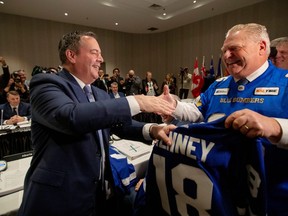 Ontario Premier Doug Ford presents a hockey jersey to Alberta Premier Jason Kenney as Canada's provincial premiers meet in Toronto, Ontario, Canada December 2, 2019. REUTERS/Carlos Osorio