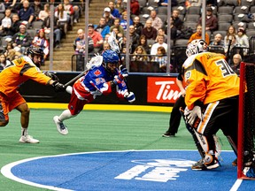 Toronto Rock’s Latrell Harris flies through the air to get a shot on New England goalie Doug Jamieson at Scotiabank Arena last night.  Ryan Mccullough/photo