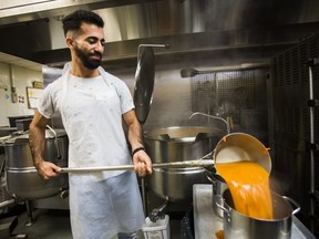Volunteer Ahmad Hamodeh pours soup in preparation for Christmas meal at the Scott Mission in Toronto, Ont. on Wednesday December 25, 2019.